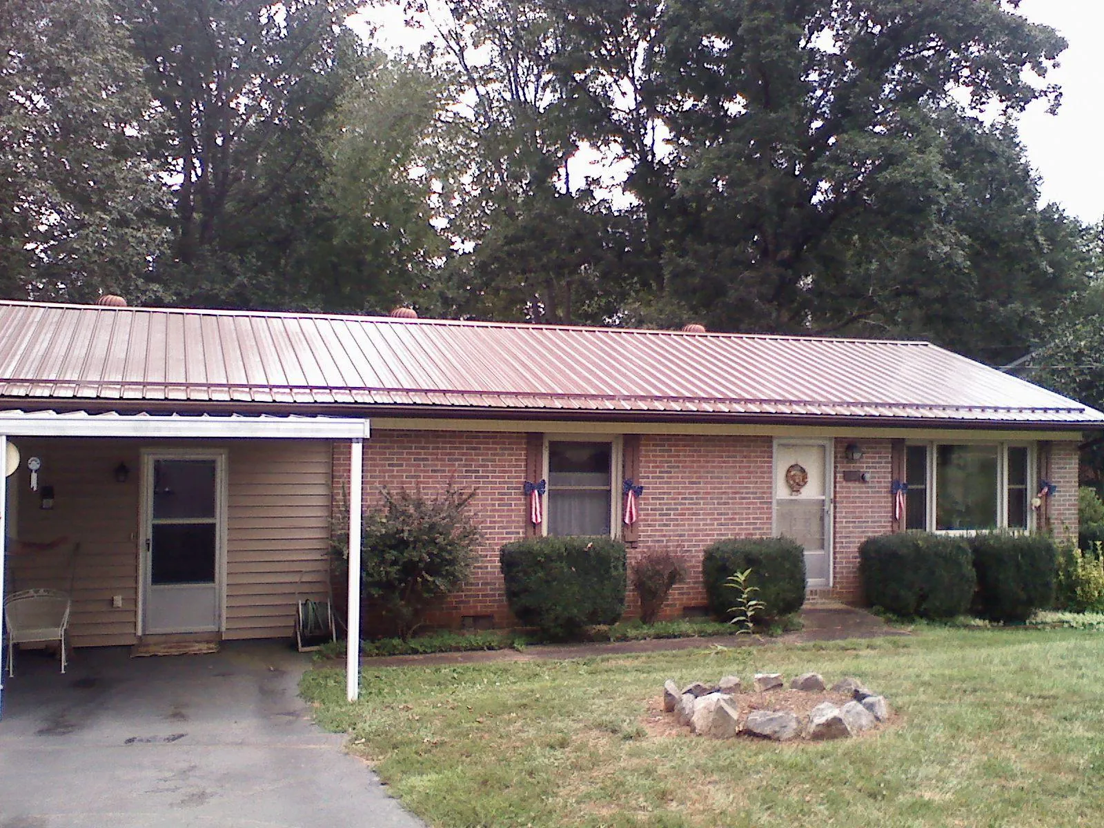Bronze metal roof and carport on a brick ranch home — Roof Repair work by our crew in Thompsons