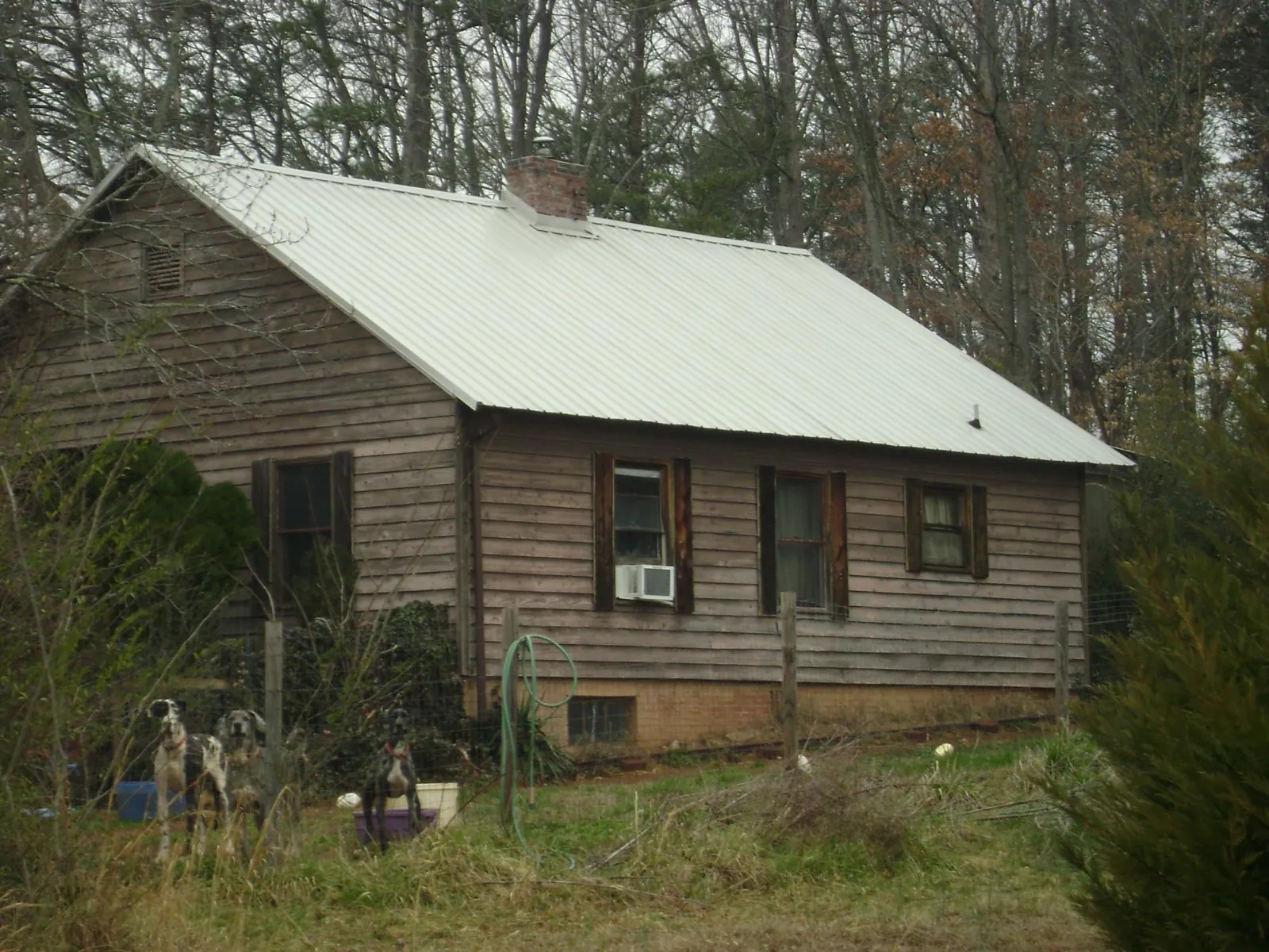 White metal roof on an old wood sided farmhouse, from a Metal Roof Installation job in Thompsons